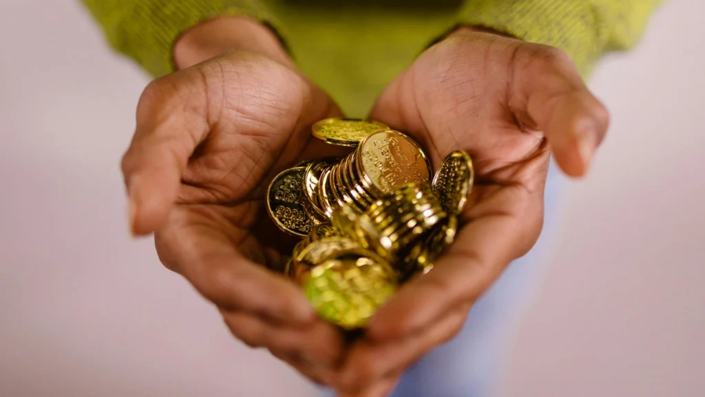 photo of man's hands holding gold coins